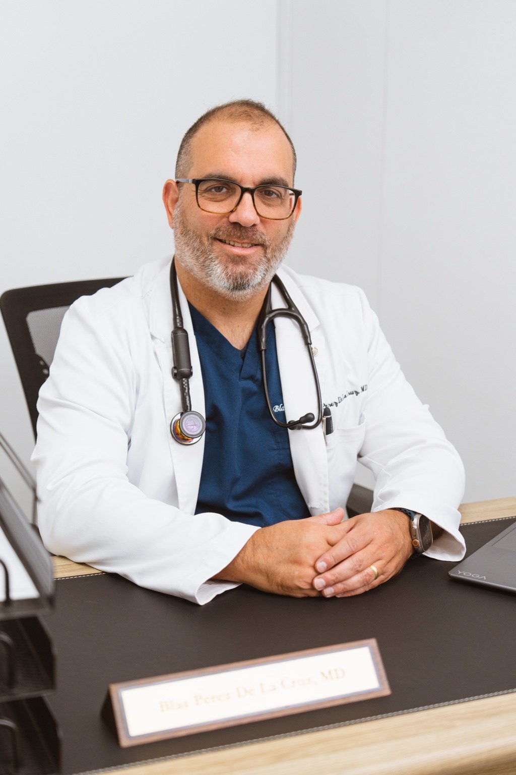 Dr. Blas Perez De La Cruz seated at his medical office desk