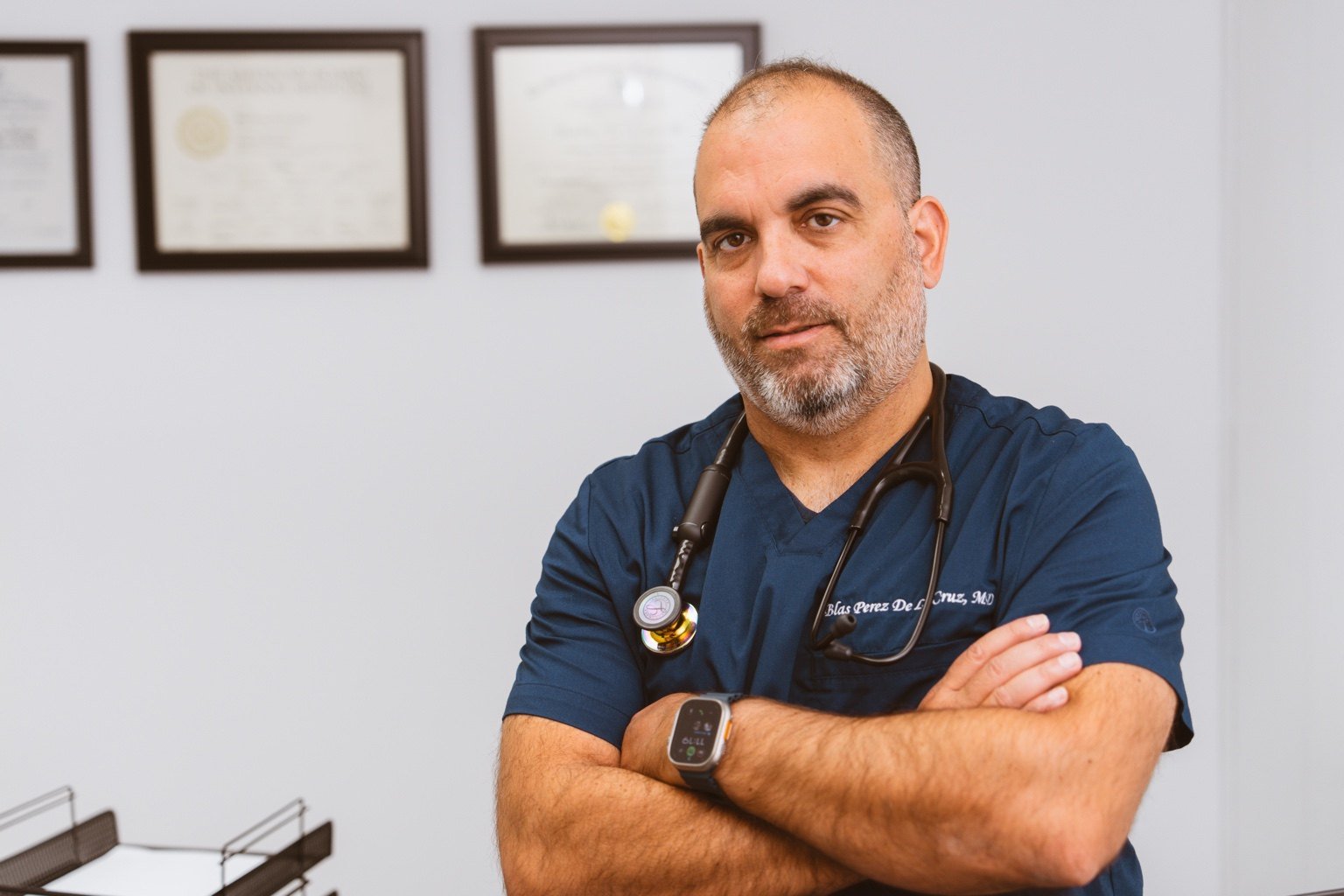 Dr. Blas Perez De La Cruz in navy scrubs